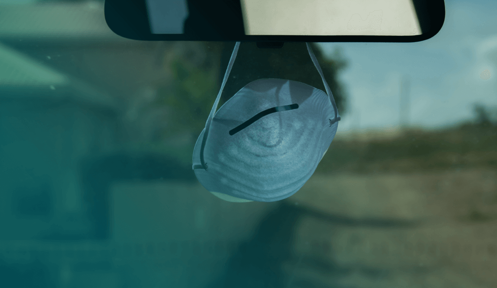 COVID dust mask hanging on the rear view mirror
