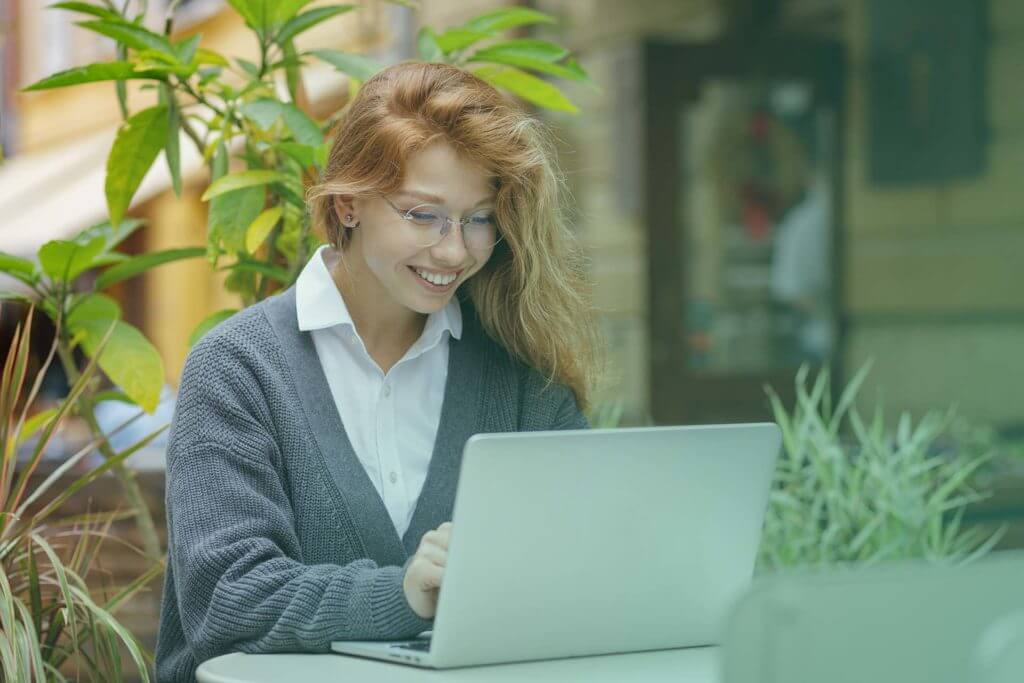 Young female student using laptop during online education course