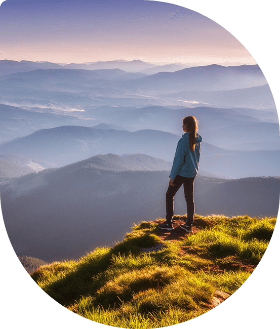 Woman standing at the top of a hike overlooking the view